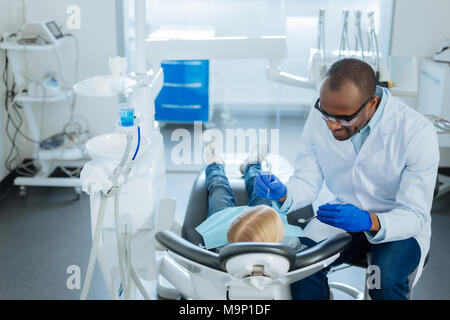 Freundliche männliche Zahnarzt im Gespräch mit Patienten vor der Überprüfung Stockfoto