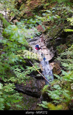Canyoning in der engen Schlucht mit Stromschnellen, die Pools und Wasserfälle in Soca Valley in der Nähe von Bovec, Slowenien gefüllt Stockfoto