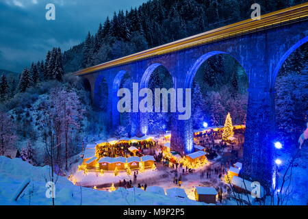 Snowy Christmas Markt unter einem Eisenbahnviadukt, beleuchtet, Ravennaschlucht, Höllental in der Nähe von Freiburg im Breisgau, Schwarzwald Stockfoto