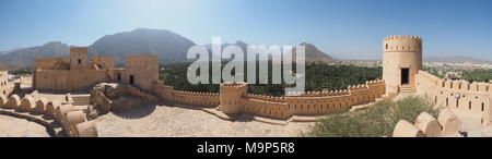 Festung von nakhl mit runden Turm und Zinnen, an der Rückseite Hajar Berge, Panoramaaussicht, Nakhl, Oman Stockfoto
