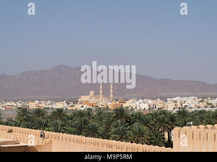 Moschee mit Minarett, Palm Oasis, in der Rückseite Al Hajar Berge, Nakhl, Oman Stockfoto