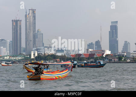 Longtail Boote an der Mae Nam Chao Phraya Fluss, skyline Financial District Bang Rak, Bangkok, Thailand Stockfoto