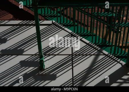 Cast diagonale Linie Schatten Muster von einem Bügeleisen Geländer auf einem Bürgersteig Stockfoto