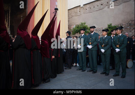 Malaga, Malaga, Spanien. 27 Mär, 2018. Büßer von ''Penas'' die Brüderlichkeit und die Mitglieder der spanischen Guardia Civil stand außerhalb der Kirche, wie sie in einer Prozession während der Heiligen Woche in Malaga. Die Heilige Woche in Andalusien ist eine der wichtigsten und berühmtesten religiösen Fest aus Spanien. Jedes Jahr werden Tausende von Gläubigen feiern die Heilige Woche in der Osterzeit mit der Kreuzigung und Auferstehung von Jesus Christus. Credit: Jesus Merida/SOPA Images/ZUMA Draht/Alamy leben Nachrichten Stockfoto