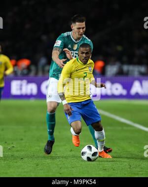 Berlin, Deutschland. 27 Mär, 2018. Brasilien ist Douglas Costa (vorne) Mias mit Deutschlands Niklas Suele während ein Freundschaftsspiel zwischen Deutschland und Brasilien, in Berlin, Hauptstadt der Bundesrepublik Deutschland, am 27. März 2018. Brasilien gewann 1:0. Credit: Shan Yuqi/Xinhua/Alamy leben Nachrichten Stockfoto