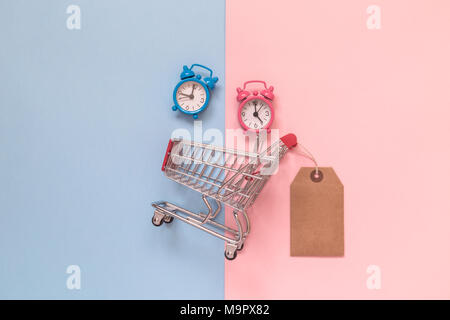 Klein Warenkorb mit leeren Preis und Wecker auf Pastell-hintergrund minimal kreatives Konzept Stockfoto