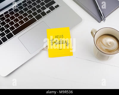 Hallo Freitag mit smiley Gesicht auf Haftnotiz auf Schreibtisch Stockfoto