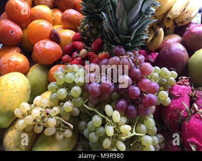 Bio-Obst im Korb Sommer Gras. Frische Trauben, Birnen und Äpfel in der Natur Stockfoto
