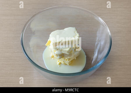 Schüssel mit Zutaten kondensierte Milch und Butter zum Kochen Butter Creme in Übereinstimmung mit den hausgemachten Rezept Stockfoto