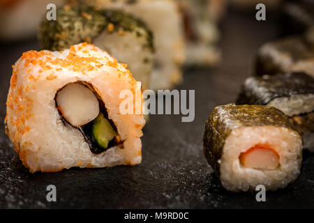 Traditionelle japanische hosomaki Sushi rollen und Uramaki auf Stein Schreibtisch Stockfoto