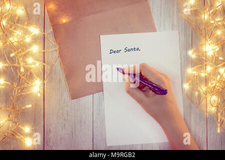 Weibliche Hand schreiben einen Brief an den Weihnachtsmann Stockfoto