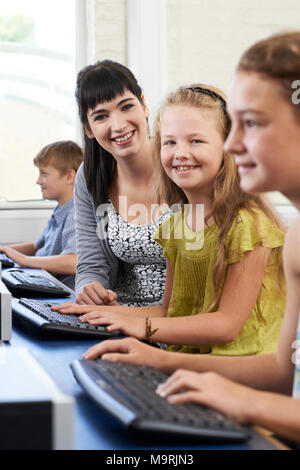 Portrait der weiblichen Schüler in der Grundschule Computer Klasse mit Lehrer Stockfoto