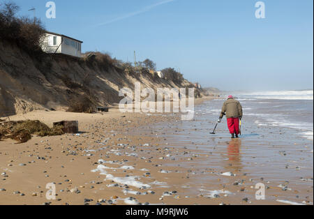 Männliche detectorist mit Metalldetektor entlang Sandstrand Hemsby, Norfolk, England, Großbritannien Stockfoto