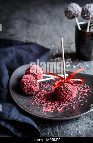 Köstliche Schokolade Kuchen pops dekoriert mit roten und weißen besprüht Stockfoto