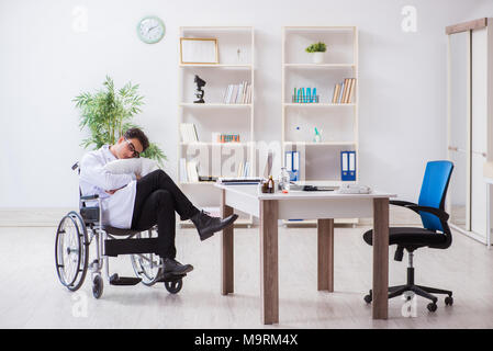 Arzt ruht auf Rollstuhl im Krankenhaus nach der Nachtschicht. Stockfoto