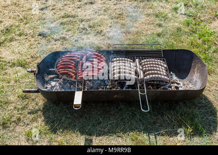 Köstliche deutsche Würstchen auf einem handwerklichen Grill Stockfoto