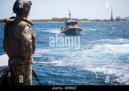 Ein Seemann, der an die in den Küstenzonen Riverine Squadron (CRS) 4, Det zugeordnet. Guam Uhren als Mark VI Patrouillenboot schleppt ein 47-Fuß-Motor Rettungsboot zugewiesen der U.S. Coast Guard Sektor Guam während einer abschleppen Übung in der Apra Harbor, Guam, 28. März 2018. CRS-4, Det. Guam ist zum Kommandanten, Task Force 75, die primäre Expeditionary task force verantwortlich für die Planung und Ausführung der Küstengebiete Riverine operations, Beseitigung von Explosivstoffen, tauchen Engineering und Bau zugeordnet und Unterwasser Bau in den USA 7 Flotte Bereich der Operationen. (U.S. Marine bekämpfen Kamera Foto von Mass Communication Specialist 1. Stockfoto