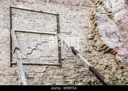 Alte Ruinen alter Mauer. Verwitterte Fassade von rostigem Eisen Bau unterstützt. Stockfoto