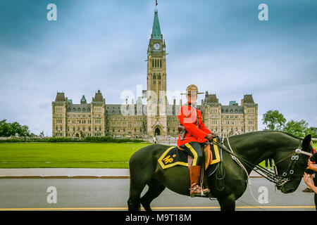 Weibliche Mountie in Rot zeremoniellen Einheitliche zu Pferd mit dem Parliament Hill oder Peace Tower im Hintergrund, Ottawa, Kanada Stockfoto