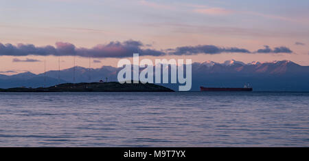 Ein Schiff in der Juna de Fuca Meerenge mit dem olympischen Berge hinter, vorbei an den Inseln Lightohuse. Von Victoria, British Columbia, Canad gesehen Stockfoto