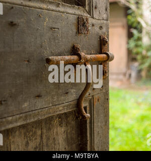 Alte Schleuse auf einer Holztür Stockfoto