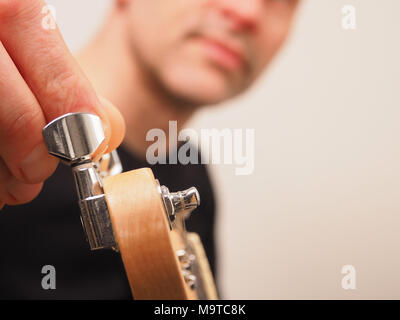 Junge Gitarrist seine E-Gitarre Tuning in einem Studio, selektiver Fokus auf die Machine Head der Gitarre Stockfoto