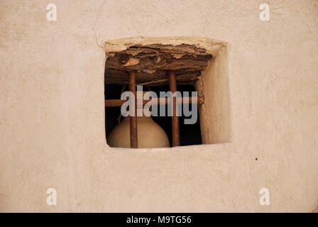 Eine Terrakotta jar hinter einem Fenster in der Festung von Nizwa im Oman. Stockfoto