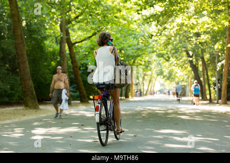 Ein Mädchen, das Radfahren und der Aufruf in der Vondelpark in Amsterdam in den Niederlanden. Stockfoto