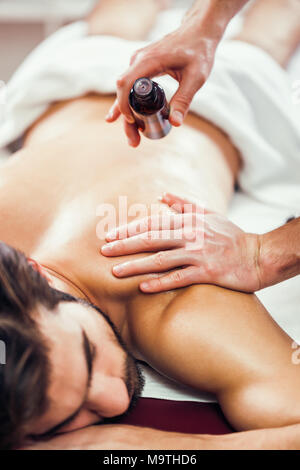 Junge Mann ist in Massage auf Spa-behandlung. Stockfoto