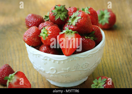 Frische Erdbeeren in der Schüssel auf Holz Tisch, organischen Garten Beeren Stockfoto