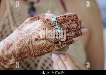 Weibliche Hände dekorativ durch Henna mit Tasse Masala Tee farbige Stockfoto