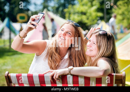 Mädchen nehmen eine selfie in einem "Glamping" Bereich am Cornbury Music Festival de Stockfoto