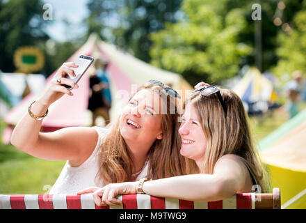 Mädchen nehmen eine selfie in einem "Glamping" Bereich am Cornbury Music Festival de Stockfoto