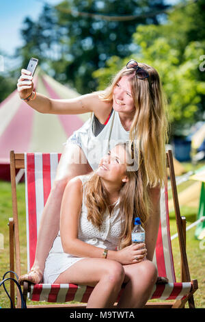 Mädchen nehmen eine selfie in einem "Glamping" Bereich am Cornbury Music Festival de Stockfoto