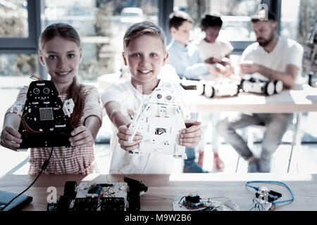 Stolz zeigen die Kinder ihre Roboter in der Werkstatt Stockfoto