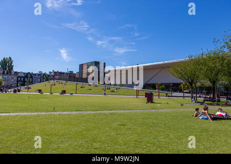 Menschen entspannend auf dem Gras in der Nähe des Stedelijk Museum in Amsterdam. Stockfoto