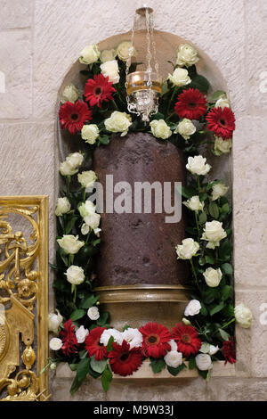 Blick auf das Relikt einer Säule in dem lateinischen Christen glauben, dass Jesus gegeißelt wurde ist mit Blumen während der Verehrung der Spalte der Geißelung Jesu innerhalb der Römisch-katholische Kapelle des Allerheiligsten oder die Kapelle der Erscheinung Jesu an seine Mutter am Heiligen Mittwoch der Karwoche, der Woche vor Ostern in der Kirche des Heiligen Grabes in der alten Stadt Jerusalem Israel Stockfoto