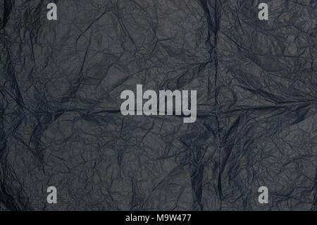 Schwarz zerknittertes Papier als Struktur. Stockfoto