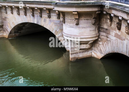 Die grotesken Masken oder Brunnen Mascarons von Germain Pilon, schmücken die Pont Neuf in Paris, aus schauen Sie über die steigende Flut der Seine inmitten der Januar 2018 Stockfoto