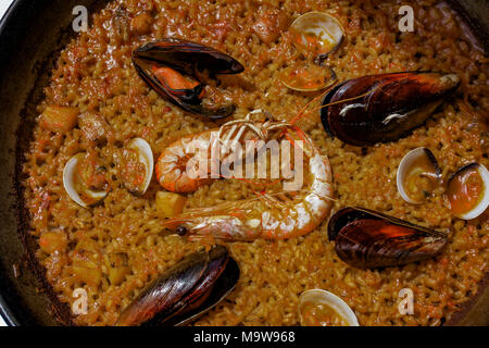 Traditionelle paella spanische Meeresfrüchte auffüllen. Nahaufnahme von einem Topf mit Valencia aufstieg Gericht mit Gekochte Garnelen, Muscheln und öffnete Miesmuscheln in der Schale Stockfoto