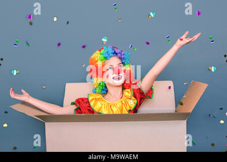 Closeup Portrait kid Clown spielen in der Pappe, Schießen popper Konfetti. Stockfoto
