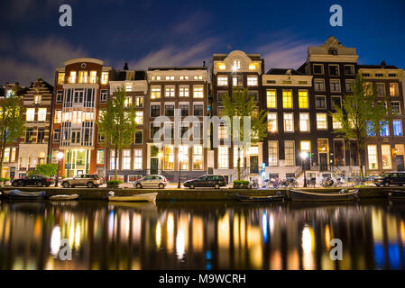 Blick auf die Amsterdamer Grachten und Böschungen entlang sie nachts. Stockfoto