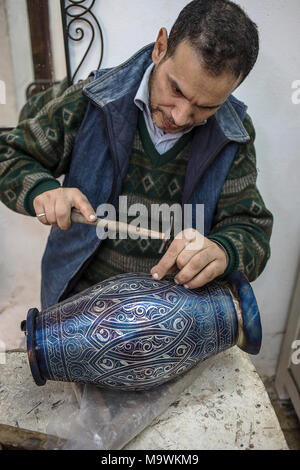 Handwerker bei der Arbeit, Souvenir, Verzieren eines Schiffes mit Silber filigran, metallhütten Souk, Medina, Meknes. Marokko Stockfoto