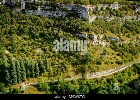 Eine Straße schneidet durch den Kalkstein Landschaft der Region Lot im Südwesten Frankreichs. Stockfoto