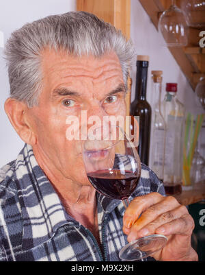 Älterer Mann trinkt ein Glas Rotwein. Stockfoto