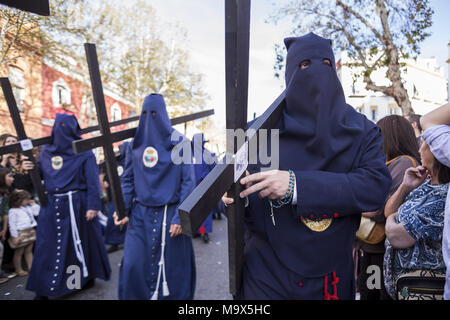 Sevilla, Spanien. 28. März, 2018. Büßer der Brüderlichkeit ''El Baratillo'' tragen Holzkreuze, die während ihrer Parade zur Kathedrale auf Heiligen Mittwoch. Credit: Daniel Gonzalez Acuna/ZUMA Draht/Alamy leben Nachrichten Stockfoto