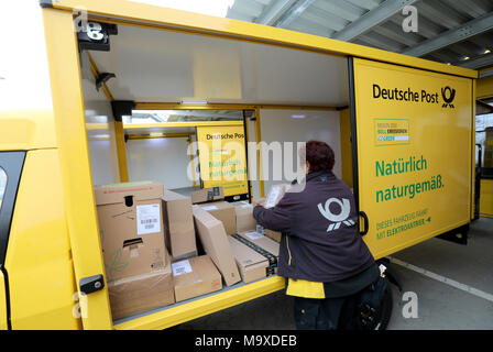 Rostock, Deutschland. 28. März, 2018. 28.03.2018, Mecklenburg-Vorpommern, Rostock: Mit der Deutschen Post Lieferung, kleine elektrische Transporter werden auf einer Presseveranstaltung geparkt werden und geladen mit Paketen. Eine street Scooter spart durchschnittlich drei Tonnen CO2 oder 1500 Litern Diesel pro Jahr. Es gibt derzeit 60 Elektrofahrzeuge in Mecklenburg-Vorpommern und ihre Zahl wird voraussichtlich bis Ende des Jahres auf 100 zu erhöhen. Rund 5500 Fahrzeuge sind bereits im Einsatz in ganz Deutschland. | Verwendung der weltweiten Kredit: dpa/Alamy leben Nachrichten Stockfoto