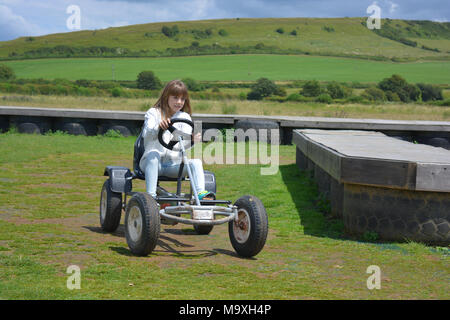 Junge Mädchen auf einem Go-kart an Abbotsbury Swannery, Dorset, England Stockfoto