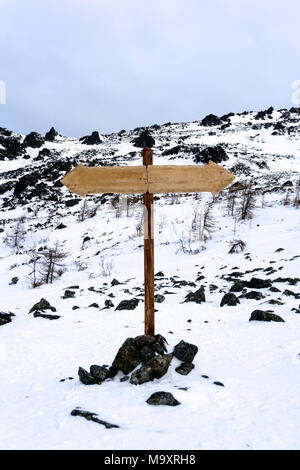 Zwei-wege-Wegweiser ohne Inschriften in einem verlassenen winter Berglandschaft Stockfoto