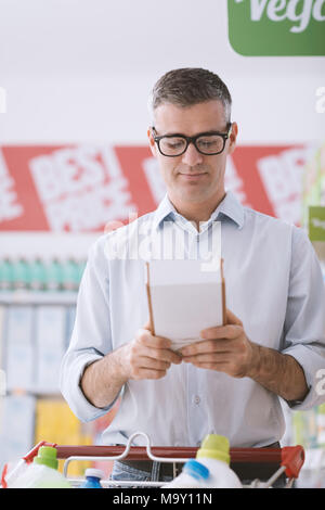 Mann tun Einkaufen im Supermarkt und Lesen von Lebensmitteln auf einem Kasten, Einkaufen und Ernährung Konzept Stockfoto